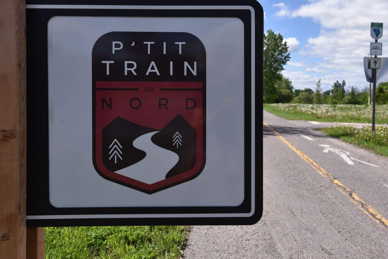 Directional signage, distance signs, and maps direct hikers and cyclists on Quebec's P'tit Train du Nord, making it one of the best trails in QC, Canada