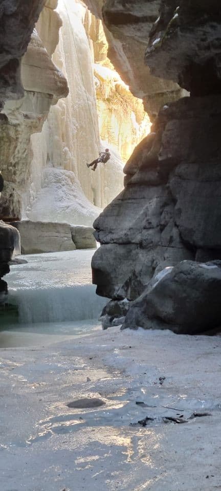 After setting the ropes, an ice climber rappels down the icefall before starting to climb