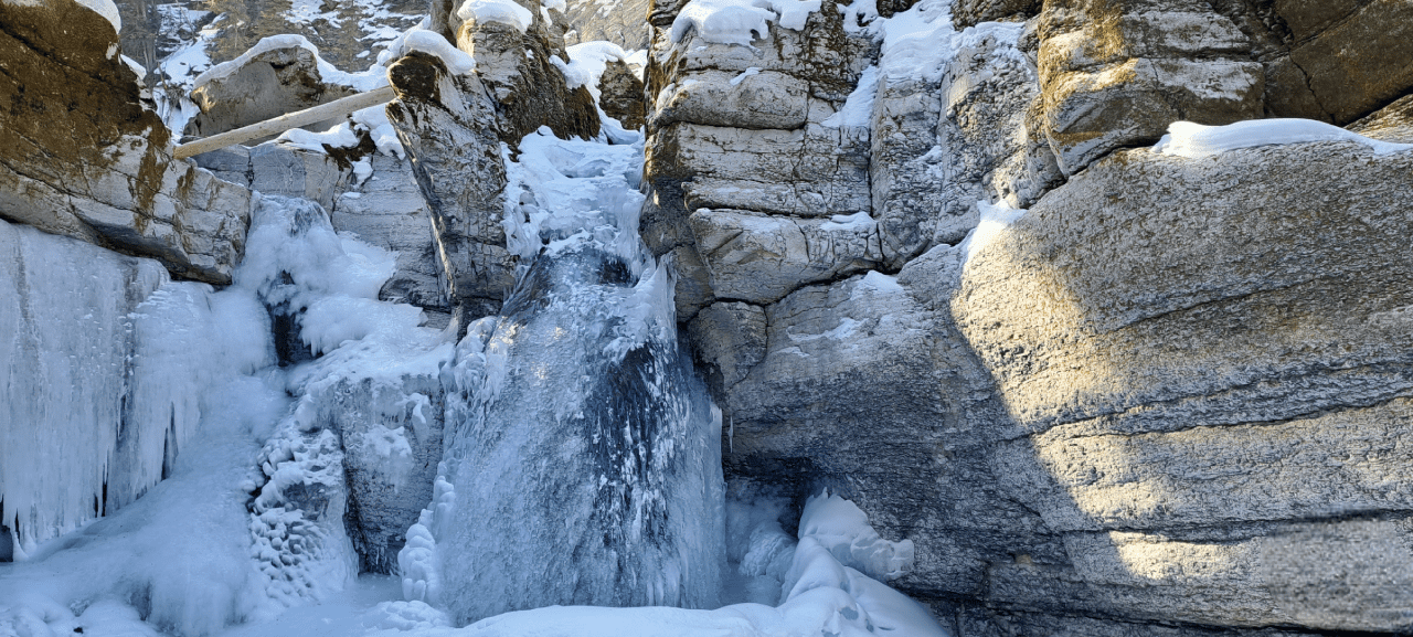 The outside of this waterfall is frozen yet the water still flows underneath.