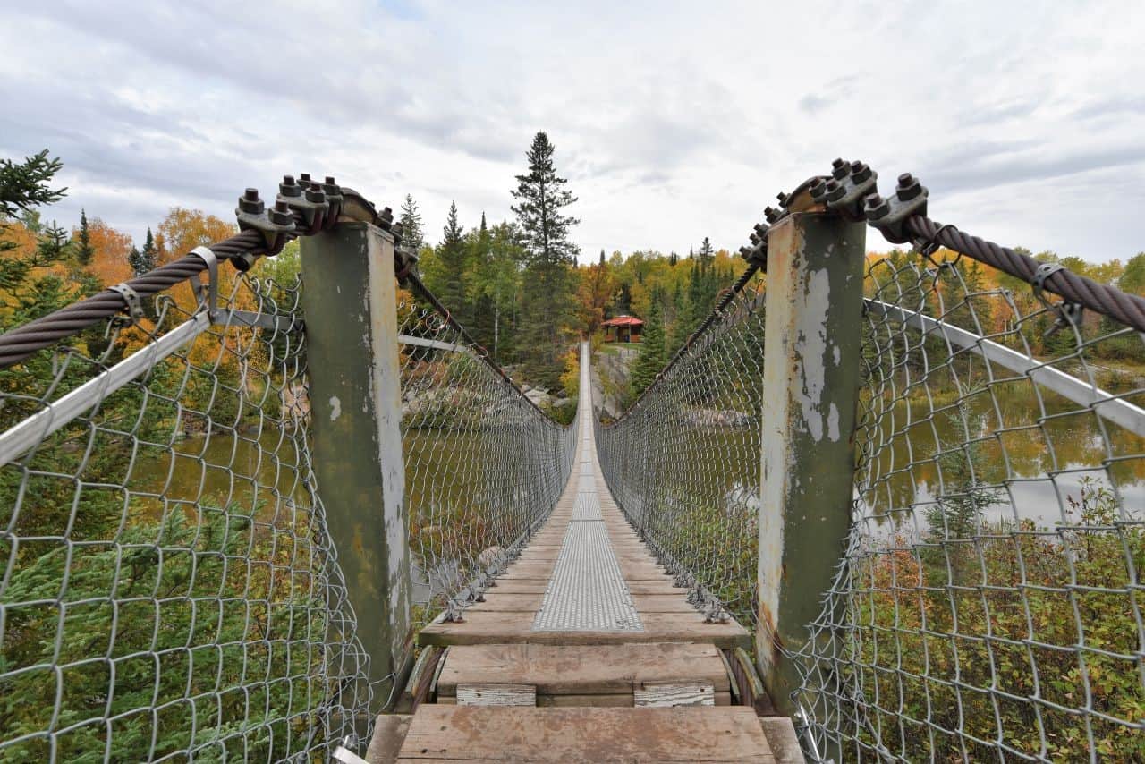 The famous Pinawa Suspension Bridge is a highlight of the Pinawa Trail for hikers, walkers, and sightseers that makes it one of the best hiking trails in Manitoba Canada