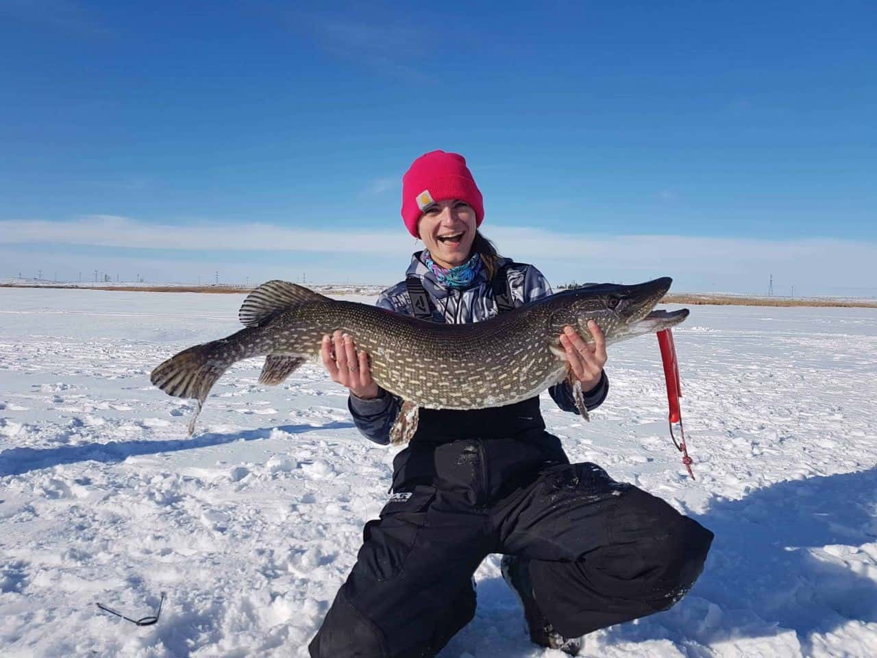 Canada Adventure Seeker and influencer Andrea Horning ice fishing in Canada.