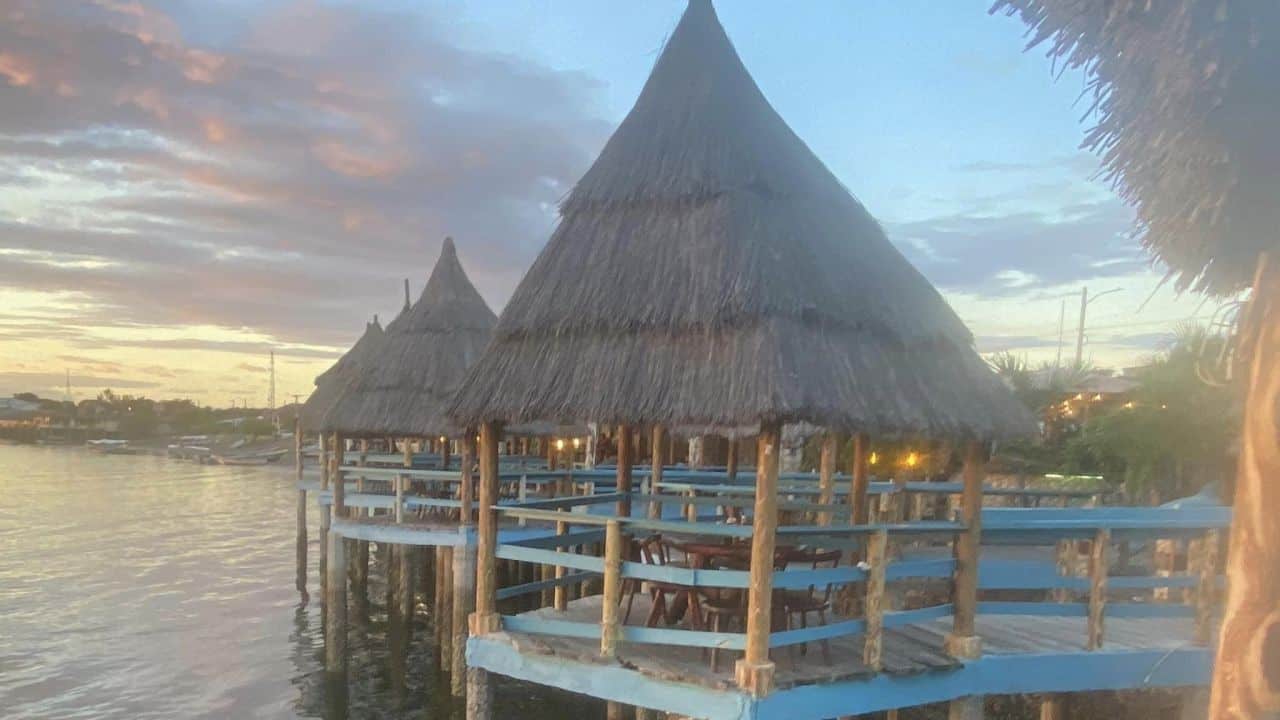 Tables are set underneath a private palapa in this over-the-water restaurant in Honduras