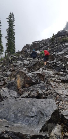 Climbing over rocks and through avalanche debris on the Marpole Hiking Trail in Yoho National Park BC Canada.