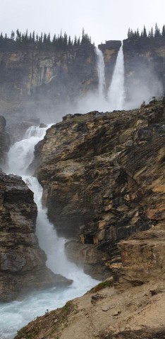 The double cascading waterfall of Twin Falls plummets 180m over the edge of the cliff to the valley below in Yoho National Park BC Canada.