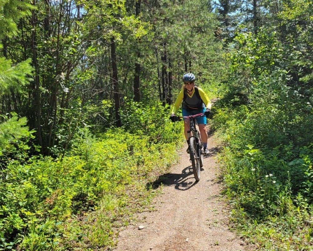 A women mountain bikes on the Moonraker Trails in Golden BC Canada