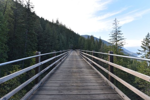 A railway trestle bridge along the Trans Canada Trail in a mountain landscape, showing how historic rail corridors create some of Canada’s most scenic and memorable long-distance cycling experiences.