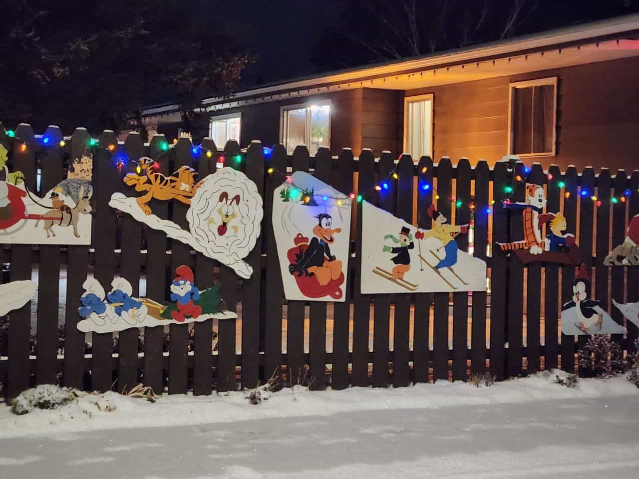 A fence in Brooks Alberta Canada decorated for Christmas in vintage Christmas boards.