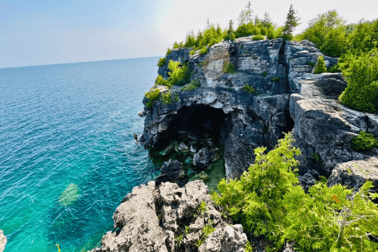 The Grotto at Bruce Peninsula National Park, a grey sea cave jutting into aquamarine waters of Georgian Bay.
