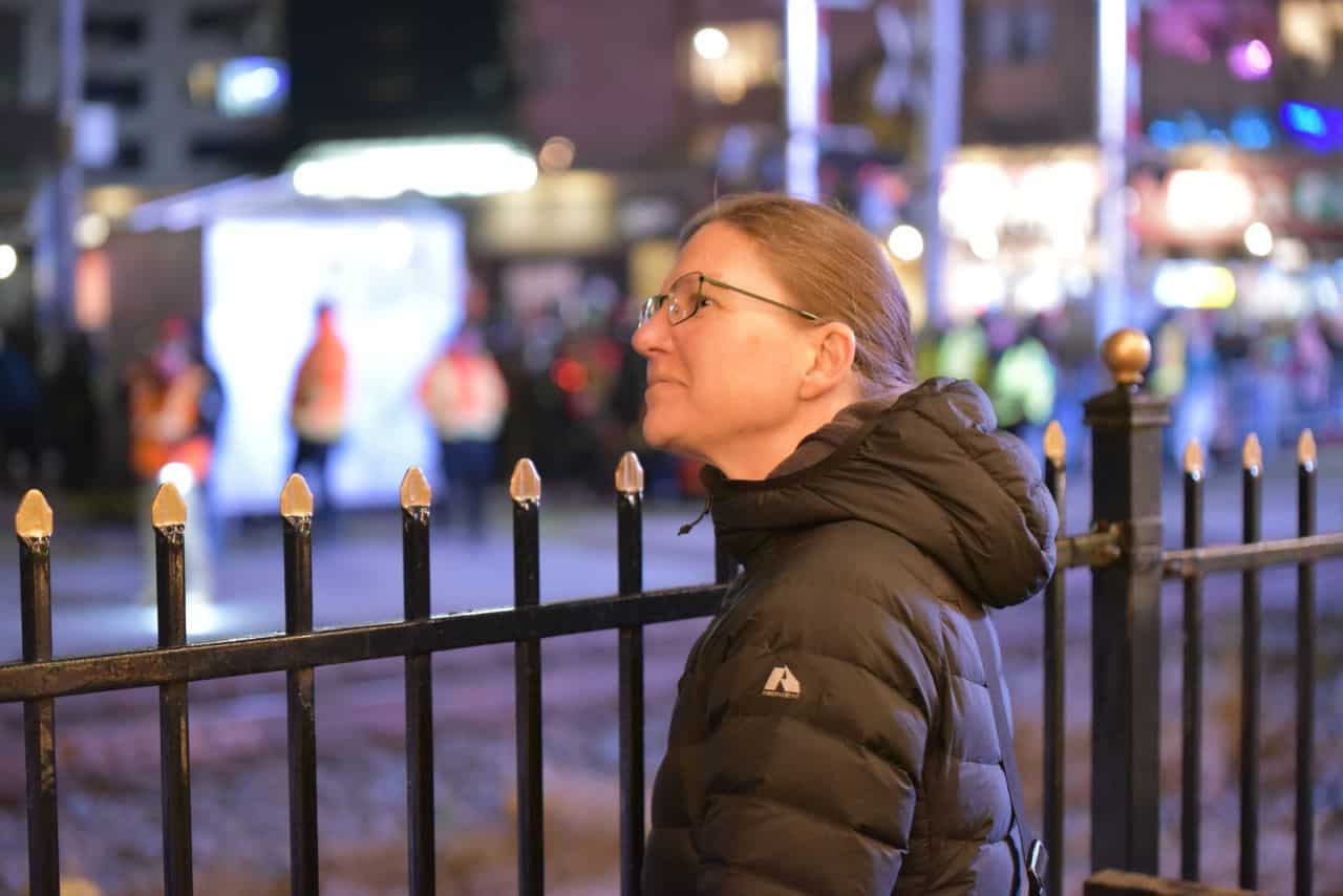 Families and friends eagerly gather along the railway tracks in London, Ontario, waiting for the CPKC Holiday Train. The festive atmosphere builds as anticipation grows for the annual holiday event of lights and music.