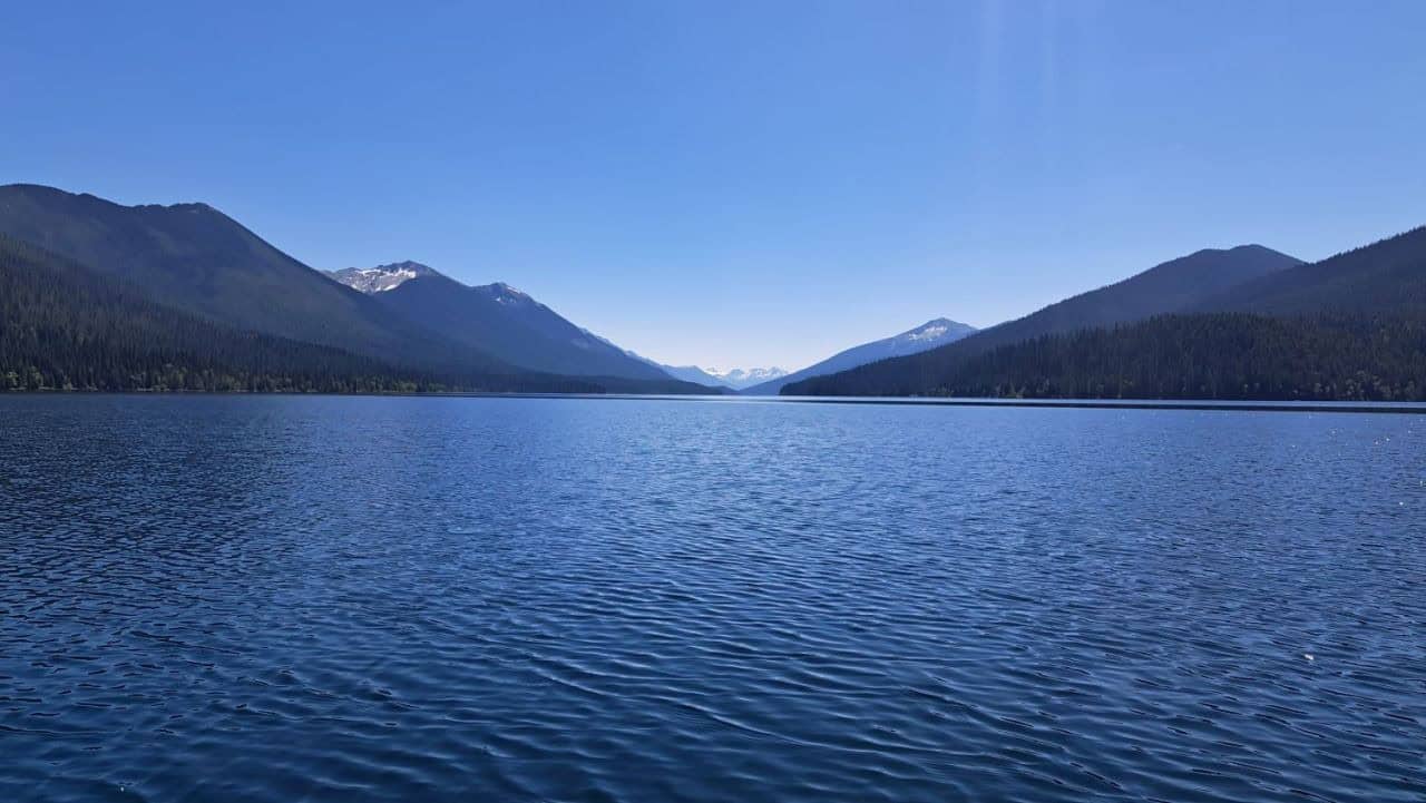 Looking down the long arm of Isaac Lake at the distance snow capped peaks of the Cariboo Mountains in Bowron Lake Provincial Park