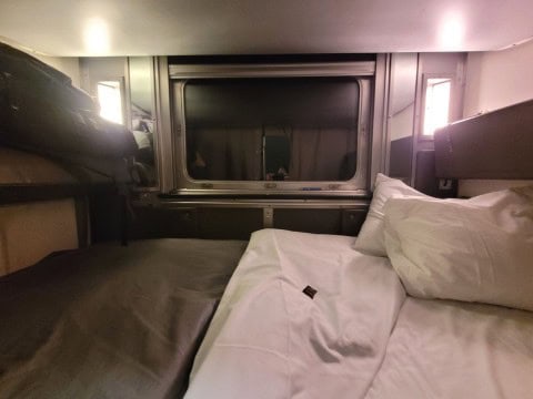 A cozy sleeper berth aboard VIA Rail’s The Canadian offers warmth and rest on the first night of the journey, gently rocking passengers to sleep as the train moves through Northern Ontario.