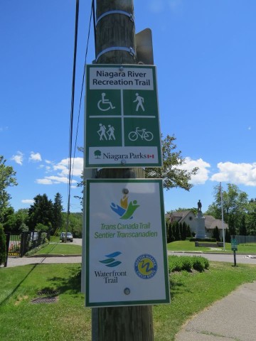Trail signpost in Ontario, Canada, highlighting connections between the Niagara River Recreational Trail, Waterfront Trail, and Trans Canada Trail, illustrating how this route links into a broader national cycling and hiking network.
