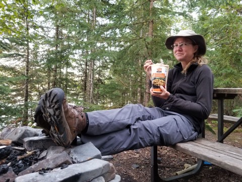 Enjoying a freeze-dried meal at a backcountry campsite along the Kabeyun Trail in Sleeping Giant Provincial Park, reflecting lightweight food planning and essential nutrition for multi-day hiking trips in remote wilderness.