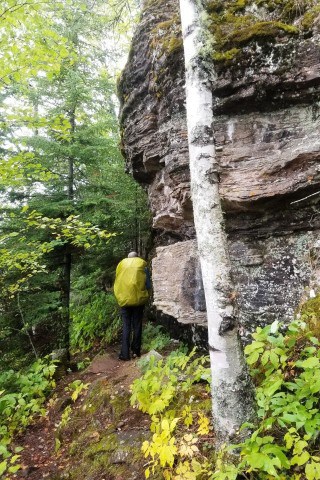 Hiking beneath towering cliffs of the Sleeping Giant in Sleeping Giant Provincial Park, where the Kabeyun Trail follows Lake Superior’s shoreline through dramatic rock formations and expansive wilderness scenery.