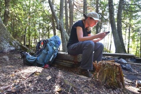 Checking a hiking app while navigating the Kabeyun Trail in Sleeping Giant Provincial Park near Thunder Bay, highlighting the importance of GPS tools and offline maps for backcountry route planning.