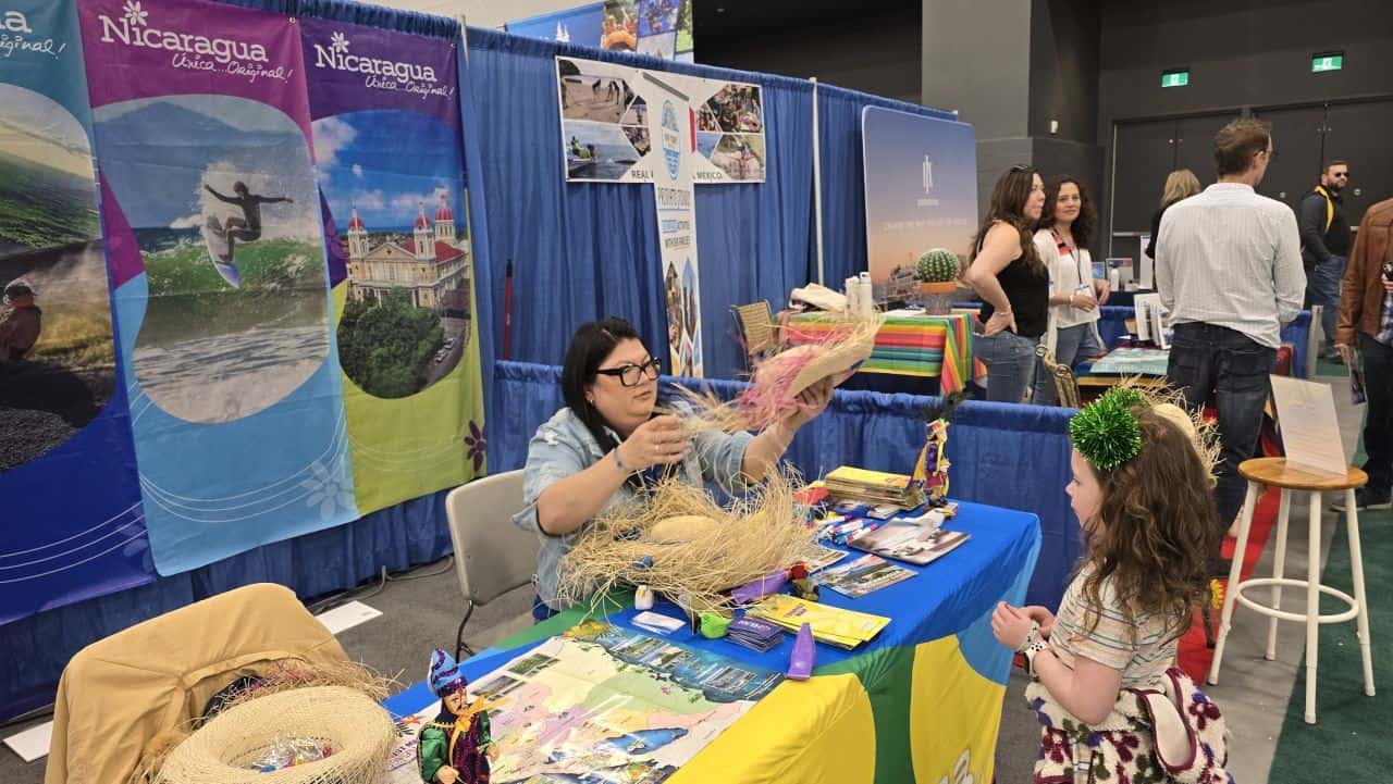 Child receiving a hat at the Nicaragua travel booth during the Calgary Outdoor Adventure & Travel Show in Calgary, Alberta.