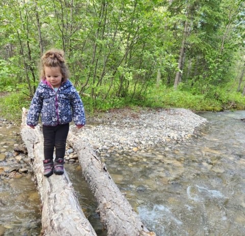 Child learning new river crossing skills in Alberta Canada