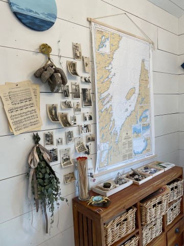 Travel photos, maps and nit-nacks hanging on the wall which visitors will enjoy when experiencing Newfoundland.