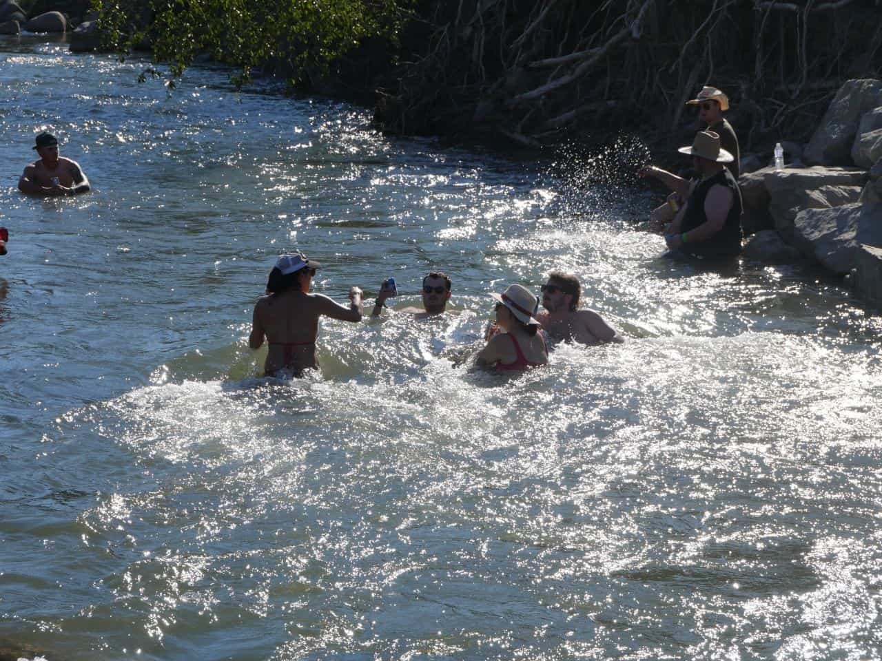 Festival goers take some time relax and cool down in the coll waters of the Coldwater River.