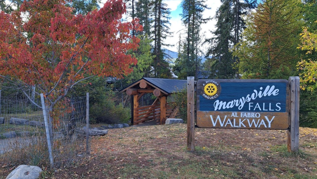 Marysville Falls Walkway near Kimberley BC - The sign and the bridge marks the start of the trail and leads onto the accessible boardwalk. Visitors get close-up views of Mark Creek before continuing along the forested path.