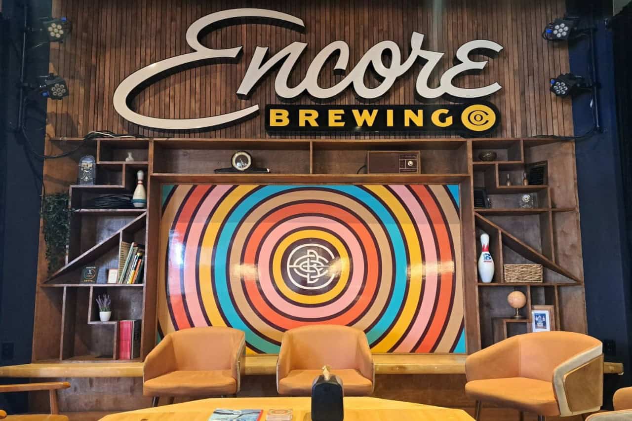 Encore Brewing Cranbrook BC - 1960s-inspired seating area with Encore Brewing Company feature wall, where the retro bowling alley theme is carried through the entire space.