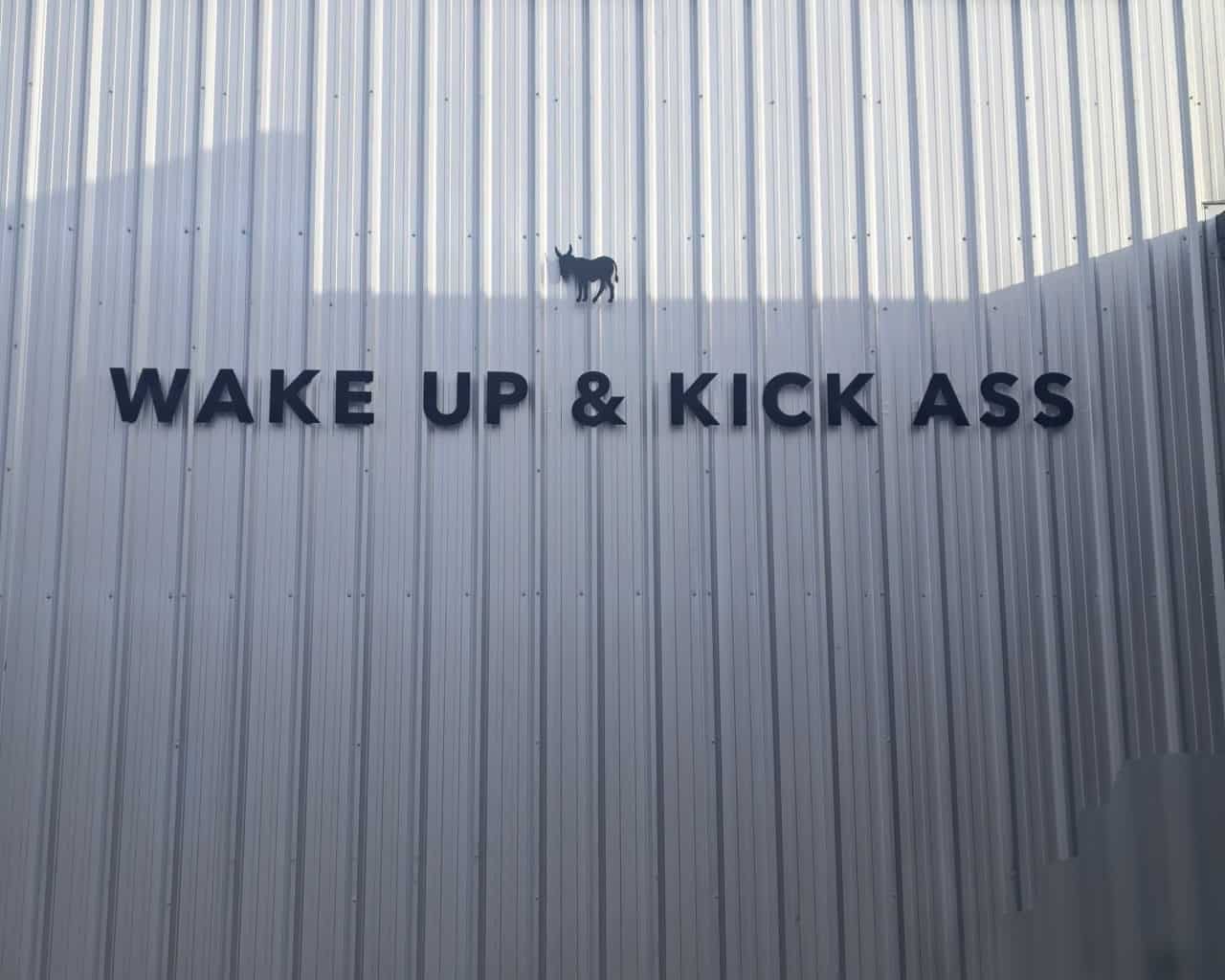 Kicking Horse Café Invermere BC Exterior – Wake Up and Kickass Motivational Saying - The exterior of Kicking Horse Café in Invermere, BC, attached to the Kicking Horse Coffee roastery. Known for its bold branding and “Wake up and Kickass” motto, this café showcases organic, fairtrade coffee at the source.