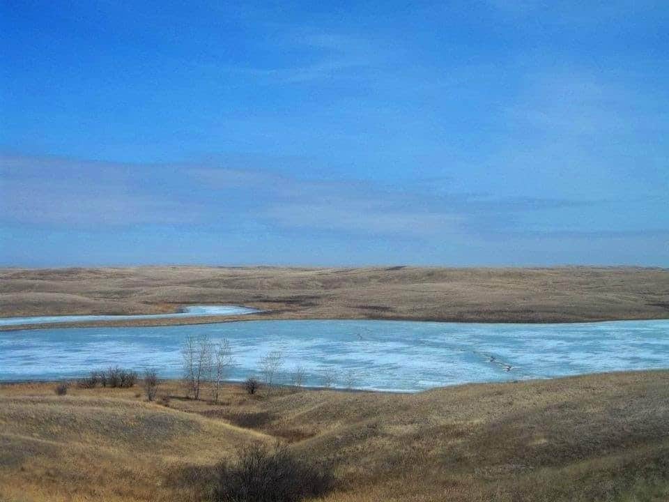 Prairie Landscape at Oro Lake - Saskatchewan Canada 2023-11-07 - The endless blue Saskatchewan skies complement the blue waters of Oro Lake in the Crane Valley area of Southern Saskatchewan.